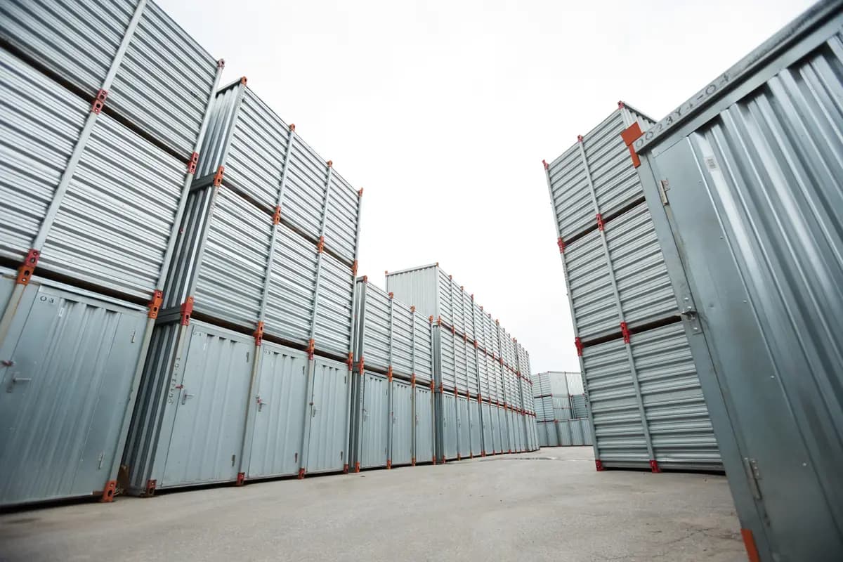 Tall stacked silver storage containers on a paved yard