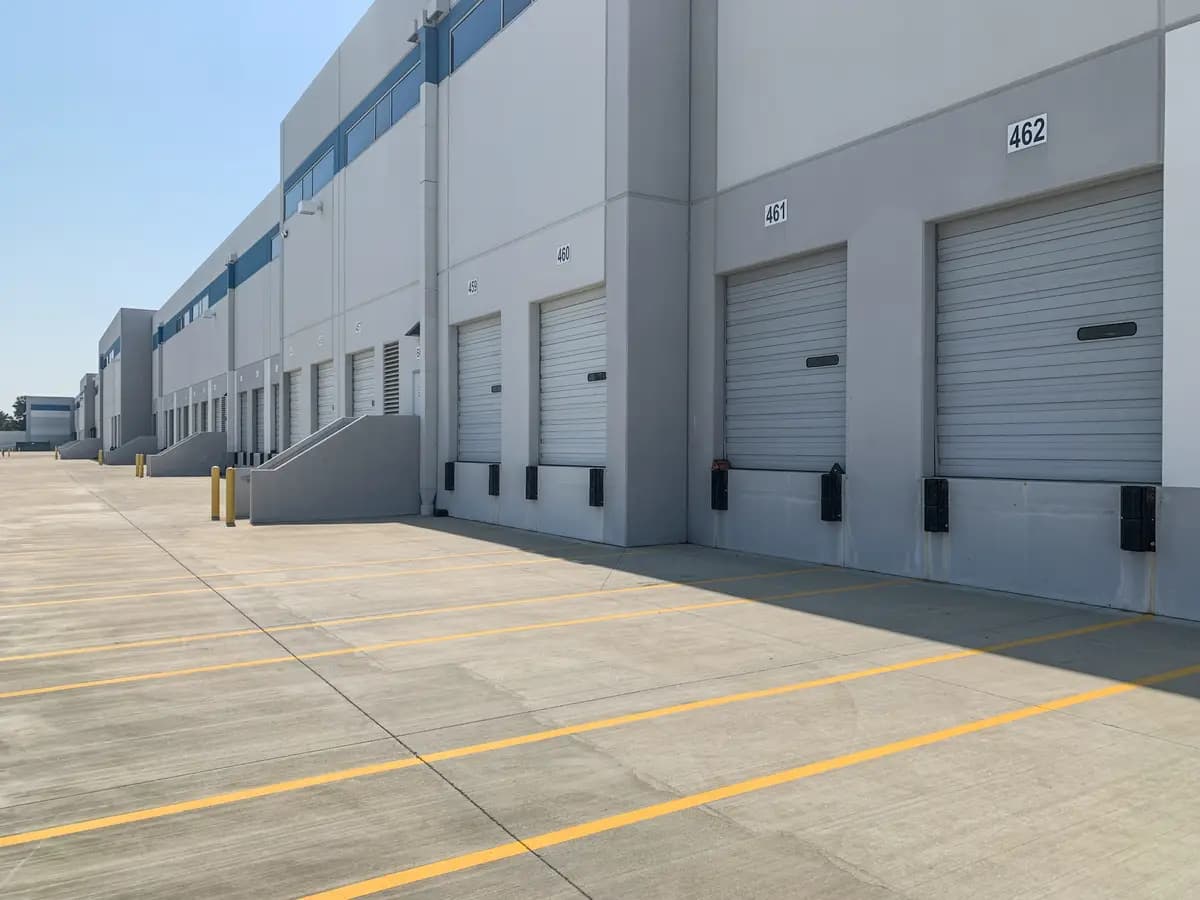 A grey warehouse exterior with loading dock doors