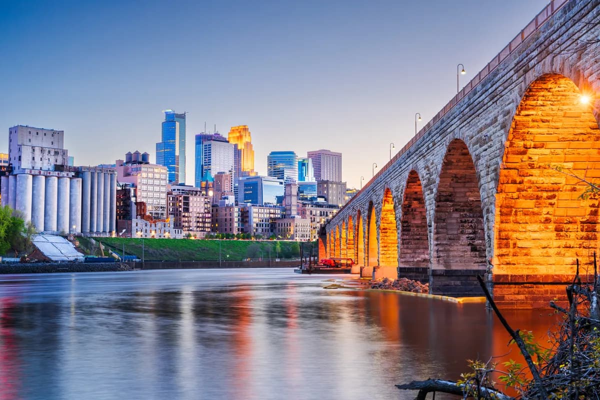 The Minneapolis skyline behind the Stone Arch bridge at dusk